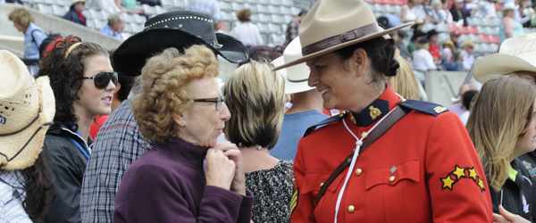 RCMP member dressed in red serge talks to a member of the public