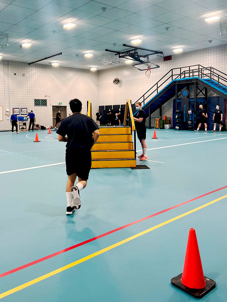 Cadet runs towards a stair case for the Physical Abilities Requirement Evaluation test