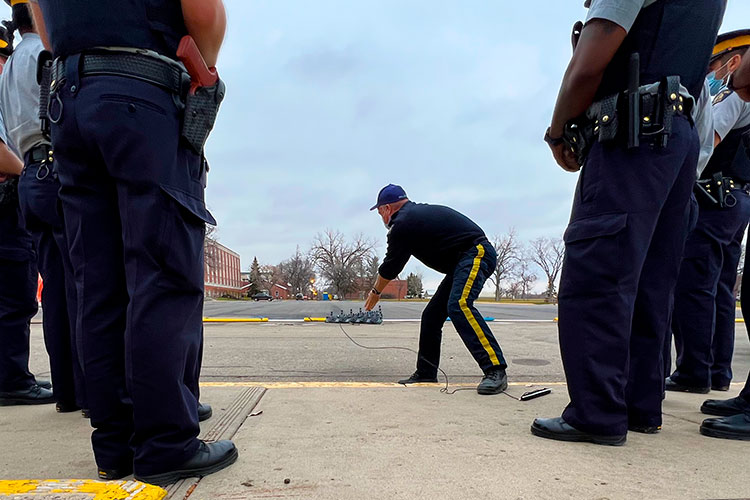 Cadets watch a demonstration of a spike belt outside.