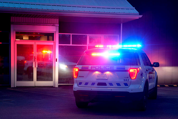 A police vehicle with red and blue lights flashing.Un véhicule de police avec des feux rouges et bleus clignotants.