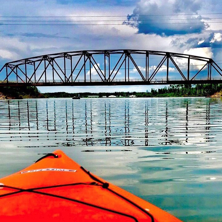 Un kayak rouge sur le lac et un pont en arrière-plan