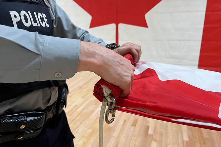 A cadet folds up a Canadian flag.