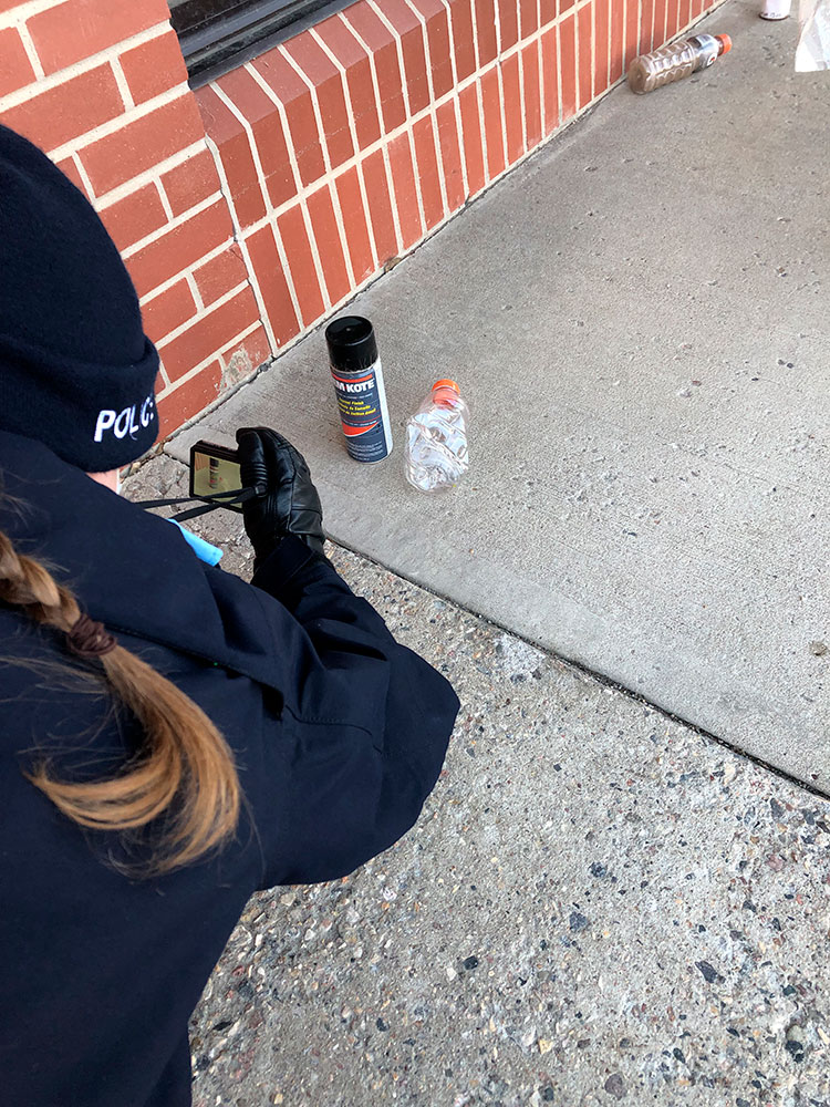 Une cadette photographie des éléments de preuve pendant un scénario de formation.