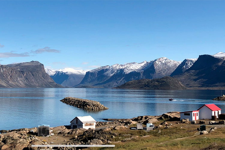 Une vue d’un lac bordé de montagnes aux cimes enneigées.