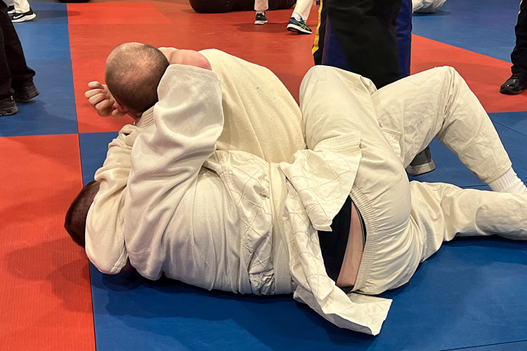 Cadets grapple on mats.