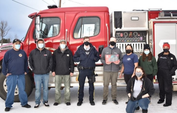 A group of adults stand in front of a fire truck