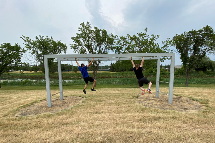 Deux cadets suspendus aux échelles horizontales pendant un parcours d'obstacles.