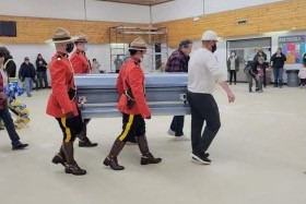 Des officiers en tunique rouge portent le cercueil de Richard Montgrand lors de ses funérailles