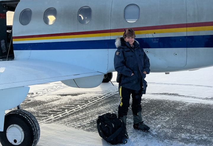 La gend. Wanda McKenzie devant l'avion de la GRC