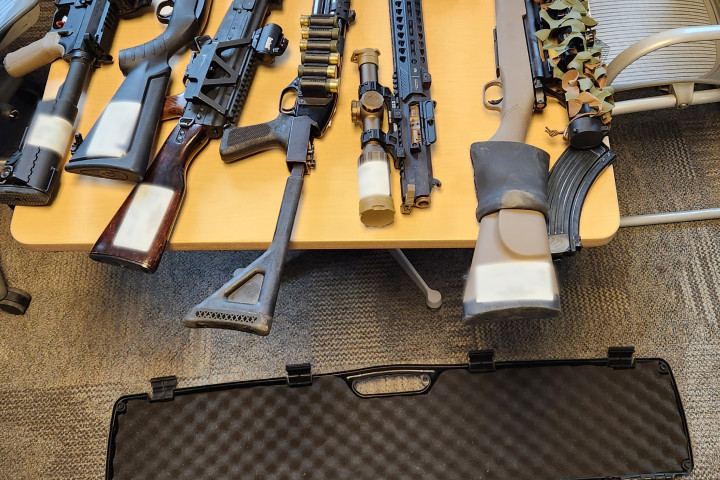 Firearms displayed on a table and on the ground