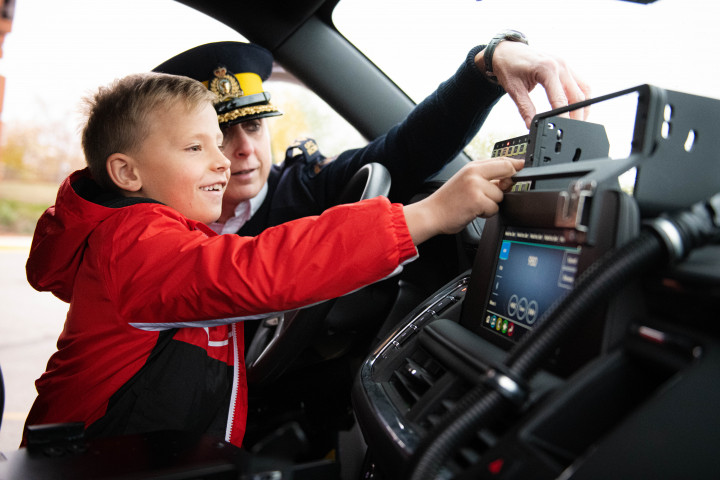 A/Commr. Blackmore and TJ inside a police cruiser